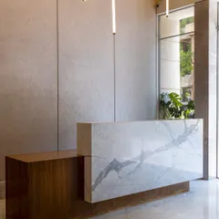 In this reception space, I created a powerful first impression through the juxtaposition of materials. The bold, veined marble of the desk contrasts beautifully with the warm timber tones, while sculptural lighting adds a sense of rhythm and balance to the refined entry experience.