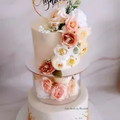 A beautiful two-tier engagement cake with a floating floral separator and a delicate gold-dusted bottom tier. This design is perfect for a glamorous celebration and is finished entirely in white chocolate ganache.