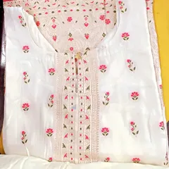 A classic white suit with delicate pink and green floral embroidery. The detailed work on the neckline makes it an elegant choice for daytime events.