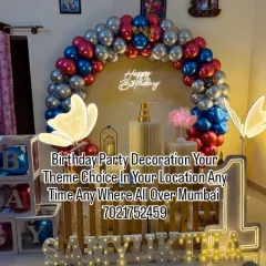 A modern butterfly theme for Samyukta's first birthday. This decoration features a stylish wooden backdrop, light-up butterflies, marquee letters, and a red, blue, and silver balloon arch.