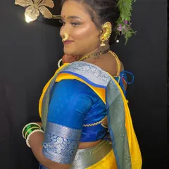 A side profile of the model, showcasing the seamless blend of the foundation and the beautiful floral hairstyle that complements the traditional look.