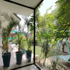 A corner of our own office, designed to prove that a connection to nature is essential for a productive and peaceful workspace. The floor to ceiling glass walls erase the boundary to the garden, making the lush greenery and natural light a core part of the indoor experience.