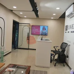 A wider view of our Lajpat Nagar reception, where you can often see patient testimonials playing on the screen.