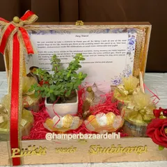 A personalized wedding hamper for Pritesh and Simran's wedding. This wooden box includes a thank you note, a live plant, and several potlis of goodies, making it a heartfelt return gift.