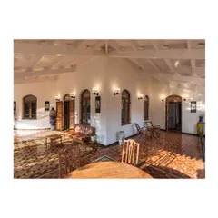 The restored veranda, where sunlight plays across the original geometric tile flooring. We focused on reviving these transitional spaces to create a seamless connection between the historic interiors and the natural surroundings, blending colonial and vernacular influences.