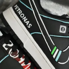 A close-up of the Mercedes F1-themed Dunks, showing the hand-painted Petronas logo. Precision is key for these designs to ensure every detail is crisp and authentic.