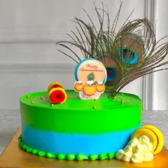 This vibrant Janmashtami cake is decorated with real peacock feathers and edible toppers. The bright green and blue colors are inspired by Lord Krishna himself.
