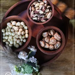 An overhead shot of my wooden dry fruit platter, showcasing a selection of premium macadamia nuts, Brazil nuts, and candied pecans. The arrangement is simple, elegant, and focuses on quality.