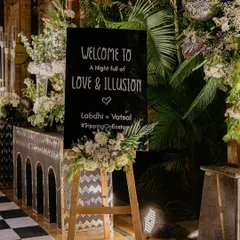 The welcome sign for the Sangeet night, setting the theme of 'Love & Illusion' from the moment guests arrived at the dramatic monochrome entrance.