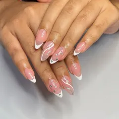 A little sparkle for your French manicure. This almond-shaped set features classic white tips, delicate silver glitter swirls, and strategically placed rhinestones for an elegant upgrade.