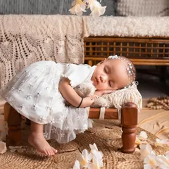 This little one is sleeping so peacefully in our dreamiest setup. The combination of the rustic wooden bench, jute rug, and delicate white flowers is just heavenly.