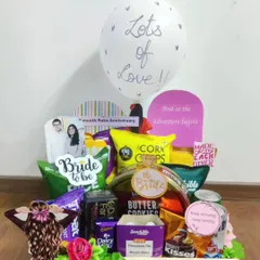 Here is a fun and vibrant hamper celebrating the bride-to-be. It's filled to the brim with her favorite snacks, chocolates, and cookies, complete with a personalized photo and a "Lots of Love" balloon to make her feel cherished as she counts down to her big day.