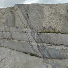 The journey of a material begins at its source. We visit quarries to select the perfect block of stone, looking for the right color, tone, and character. This raw, striated granite block is the first note in a complex architectural composition.