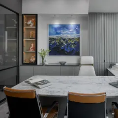 We designed this cabin to be both functional and artistic. A large, dramatic landscape painting serves as the focal point, complemented by sleek grey cabinetry with built-in display shelves for a personal touch.