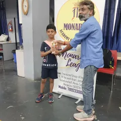 Siddanth receiving his trophy as the U11 Semi-Finalist at the 1st Monarch League, showing his consistent performance.