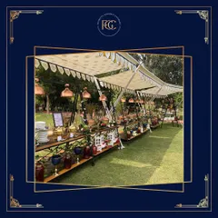 A beautiful daytime buffet setup under a canopy at an outdoor wedding. The long tables are laden with food, showcasing an extensive spread designed for a large celebration.