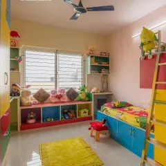 A colorful and playful kid's room designed for fun and function. It features a low bed with storage, a bay window seat with toy cubbies, and a bunk bed ladder, making the most of the space.