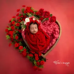 Color can add so much emotion to a portrait. This vibrant, all-red theme uses a heart-shaped prop and rich floral arrangements to create a powerful and passionate statement of love for this beautiful baby girl.
