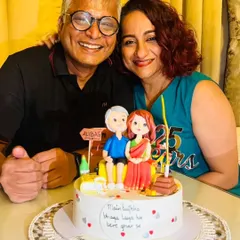 The happy couple celebrating their 25th anniversary with the cake that tells their unique love story.