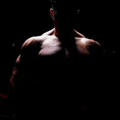The silhouette of a well-built physique. This dramatic shot captures the result of dedication to strength training and bodybuilding at our academy.