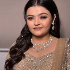 For her engagement, we went with a glitzy yet sophisticated look. The makeup features a classic brown smokey eye, while the hair is styled in soft waves with delicate pearl accessories for a touch of sparkle.