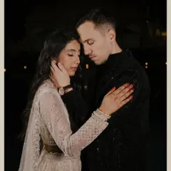 A close-up, tender moment between the couple, captured at night. The soft lighting and their gentle embrace create a deeply romantic and emotional portrait.