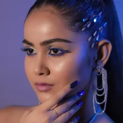 A close-up on the sharp, cobalt blue graphic eyeliner and flawless skin, key elements of this modern editorial style.