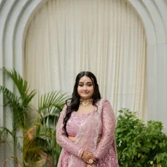 A full portrait of the bride in her pastel lehenga. The makeup is designed to be soft and radiant, letting her natural beauty and happiness be the focus.