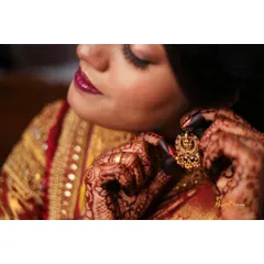 A detailed shot of the bride putting on her traditional earring. Capturing these final touches is part of the "getting ready" story.