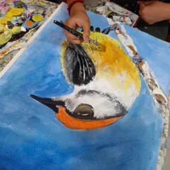 A student works on an acrylic painting of a bird, learning to layer colors and create texture. Our regular classes provide a supportive environment to practice and refine painting skills at your own pace.