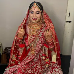 The smile of a happy bride says it all. Here she is, looking radiant in her red wedding lehenga, with makeup that enhances her joy.