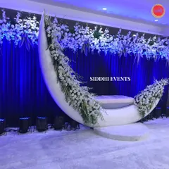 A truly unique and magical seating element, this crescent moon swing is adorned with white flowers, creating an unforgettable, 'insta-worthy' moment for the couple.
