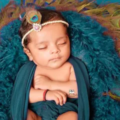Capturing the divine innocence of a sleeping newborn. This shot from our Janmashtami series uses soft fabrics and a peacock feather headband to complete the 'natkhat Nandlal' look.