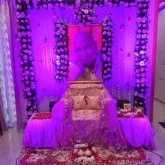 The same serene satsang decoration can be transformed for an evening gathering with the use of colored lighting. Here, purple lights are used to create a deep, meditative ambiance for the event.
