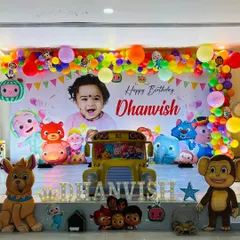 A full view of the Cocomelon setup, including a school bus prop and light-up marquee letters.