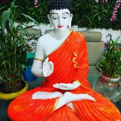 A large, beautifully painted Buddha statue in a classic orange robe. This piece makes a significant and peaceful statement in any space.