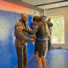 A belt promotion ceremony. Here, a student is awarded a new belt, recognizing the time and effort she's put in on the mats.