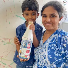A proud mom and son duo with their finished decoupage bottle. They transformed an old ketchup bottle into a beautiful, beach-themed decorative piece.