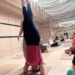 A view from the side during a headstand workshop. Notice the other participants resting or observing; every part of the process, including rest, is a part of learning.