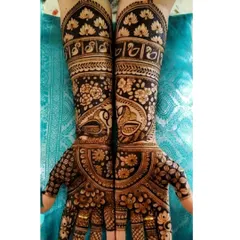 A dense and dark-staining design that heavily features peacocks on the hands and swans on the forearms. The negative space filled with black henna makes the motifs pop.