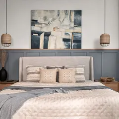 A master bedroom should be a true retreat. Here, the design is centered around tranquility, with a light beige upholstered bed set against soothing grey wainscoting. The abstract canvas and oak side tables complete this modern farmhouse bedroom, creating a perfect balance of comfort and rustic elegance.