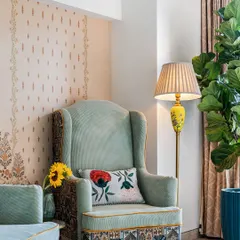 An accent chair can turn a bedroom into more than just a place to sleep. We added this customized armchair to create a cozy reading corner in this colonial-style bedroom, adding both function and personality.
