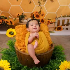 A big, happy smile from this baby in our sunflower bucket setup. The combination of the rustic props and bright flowers makes for a beautiful and joyful portrait.