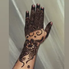 A clear view of the fresh henna paste for this floral and swirl design. Notice the neatness of the lines and the solid fill, which are key to a flawless final stain.