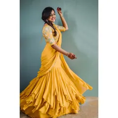 Capturing movement and joy in a modern ethnic outfit. This shot showcases a unique ruffled lehenga-saree, with the model's twirl creating a dynamic and lively fashion portrait.