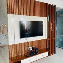 This entertainment unit features a striking backdrop of vertical wooden slats and a clean white panel for the TV. The design is complemented by an open wooden partition that adds depth and character to the living space.