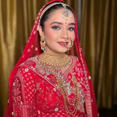 A full portrait of a gorgeous bride in her red lehenga. My goal is always to ensure the makeup complements the entire look, from the intricate outfit to the heavy jewellery, making you feel confident and beautiful from head to toe.