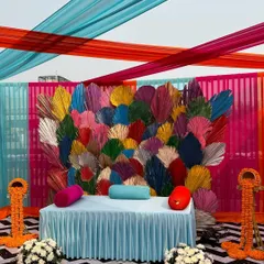 The main seating area for the Mehendi, featuring a backdrop made of colorful dried palm leaves. This unique element added a modern and artistic touch to the traditional ceremony.