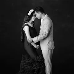 A timeless black and white portrait of a couple sharing a quiet, intimate moment. The floral headpiece adds a touch of softness to this beautiful image.