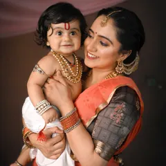 A tender moment between a mother and her little Kanha. For my cultural and festive photoshoots, I provide authentic traditional outfits and detailed backdrops to create timeless, artistic portraits like this one.
